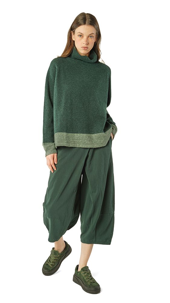 Grüne oversized Strickjacke mit Turtleneck, weite Hosen und grüne Sneakers – lässiger Herbstlook.