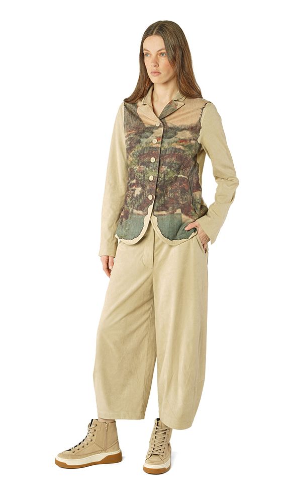 Frau trägt beige Overalls mit floraler Weste und robusten Schuhen, lässiger Stil.