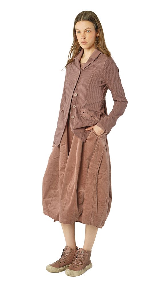 Frau trägt oversized tailliertes Beige-Kleid mit Weste und robusten Schuhen, lässiger Stil.
