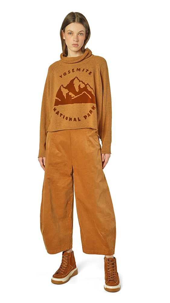 Person trägt beiges Yosemite-Nationalpark-Shirt und weite Hosen mit robusten Schuhen.