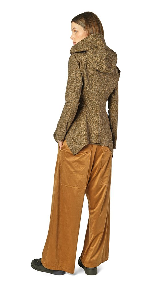 Frau trägt olivfarbenen Tweed-Blazer mit Schal, weite beige Hosen und schwarze Schuhe.
