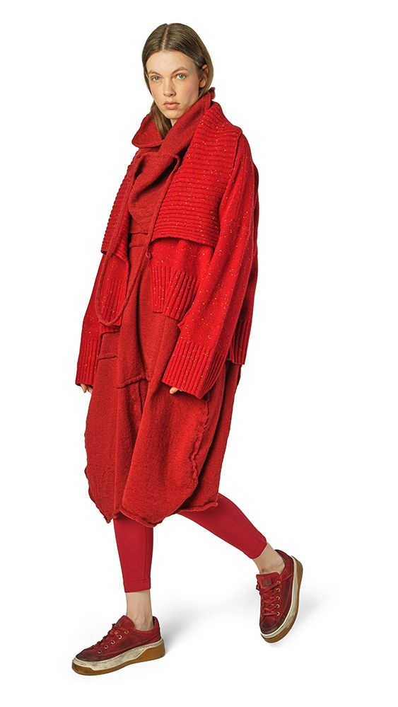 Frau trägt oversized roten Wollmantel mit langen Ärmeln und passenden Beinlingen, rote Sneakers.