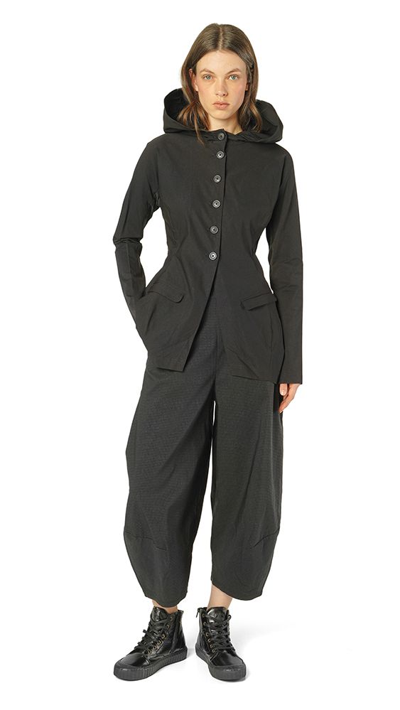 Schwarzer Overall mit Kapuze, weitem Schnitt und schwarzen Stiefeln.