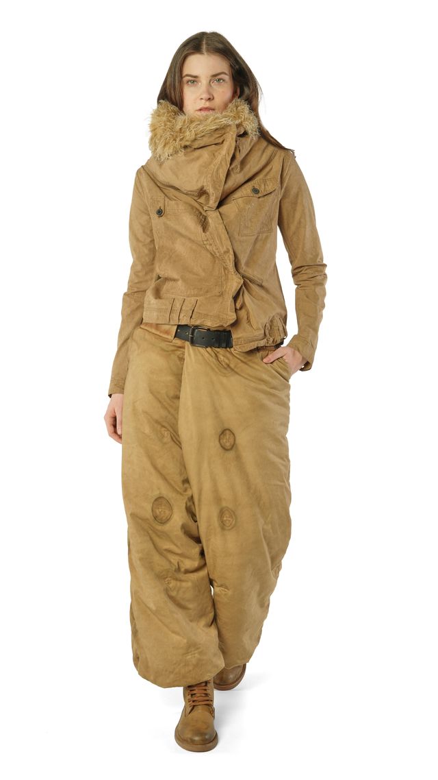 Frau in beige Militärjacke mit Pelzkragen und weiten Hosen, stilvoll mit Gürtel und Stiefeln.