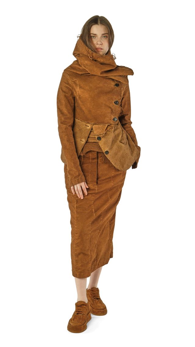 Frau trägt braunen oversized Cordmantel mit weitem Schnitt und Stiefeln, elegant und lässig.