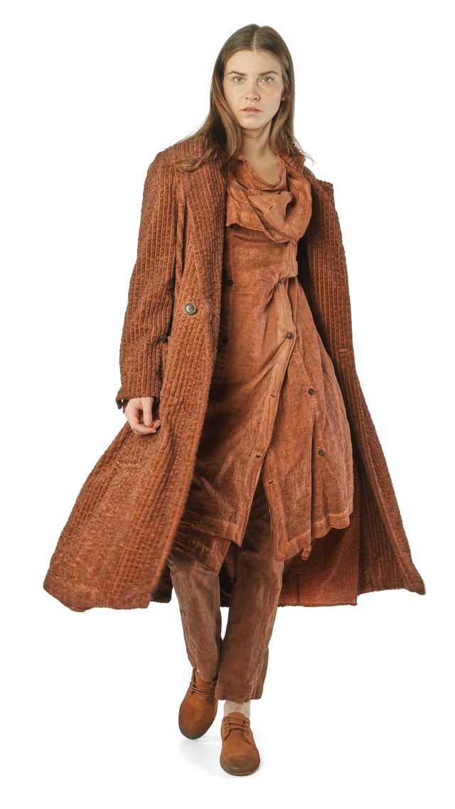 Frau trägt langes, braunes Wollkleid mit oversized-Kardigan und Stiefeletten, elegant-bohème Stil.
