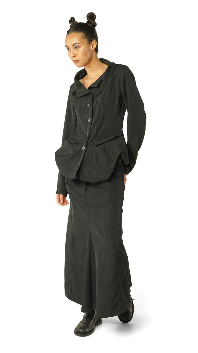 Frau trägt eleganten schwarzen oversized Pullover mit Weste und weitem Rock, Haare zu zwei Dutts.