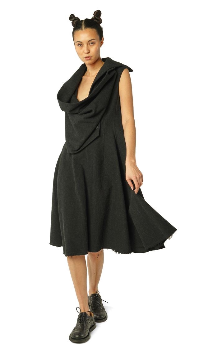 Frau trägt elegantes, schwarzes oversized Kleid mit Puffärmeln und Bommel-Haarreif.