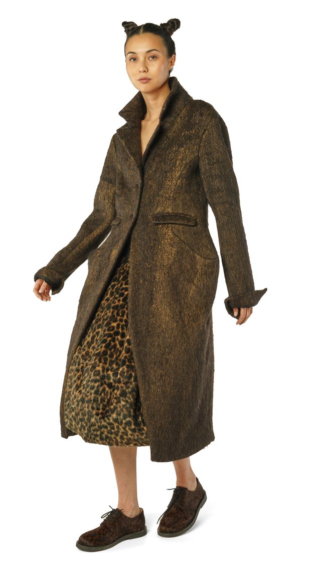 Langer, gemusterter Wollmantel mit Leopardenakzenten, schwarze Stiefeletten, Accessoires mit Ohren.
