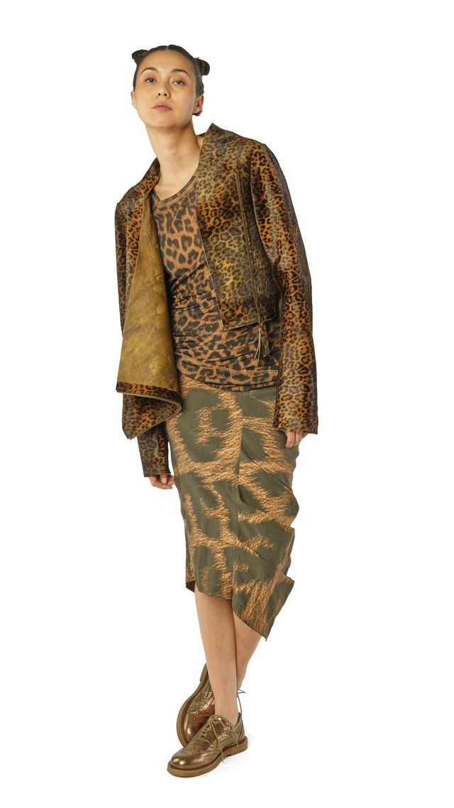 Person trägt leopardgedrucktes Langarm-Shirt und -kleid mit grünen Mustern, beige Schuhe.