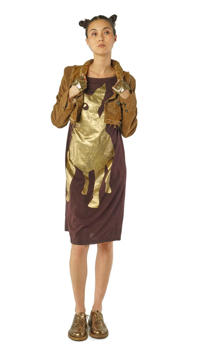 Kostümierte Person in marronem Kleid mit goldener Giraffen-Illustration und braunem Umhang.